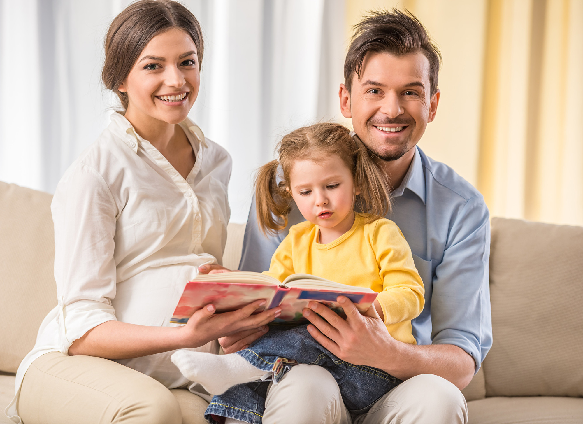 父母陪年幼的女儿阅读。(Fotolia)
