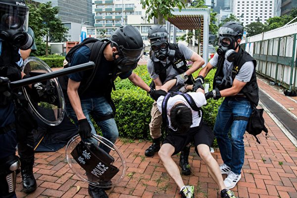 Police arrest a man (C) during violent clashes with protesters in Hong Kong on June 12, 2019. - Violent clashes broke out in Hong Kong on June 12 as police tried to stop protesters storming the city's parliament, while tens of thousands of people blocked key arteries in a show of strength against government plans to allow extraditions to China. (Photo by ISAAC LAWRENCE / AFP) (Photo credit should read 