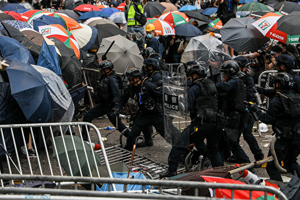 Police clash with protesters during a rally against a controversial extradition law proposal outside the government headquarters in Hong Kong on June 12, 2019. - Violent clashes broke out in Hong Kong on June 12 as police tried to stop protesters storming the city's parliament, while tens of thousands of people blocked key arteries in a show of strength against government plans to allow extraditions to China. (Photo by DALE DE LA REY / AFP) (Photo credit should read 