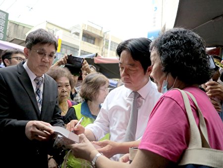 前行政院长赖清德前往小港二苓市场拜票，粉丝拿着他的书请求签名。