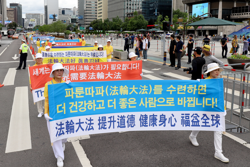 2019年7月20日，南韓法輪功學員在首爾舉行反迫害20年遊行，傳播法輪功真相呼籲中共停止迫害。圖為「法輪大法 提升道德 健康身心 福益全球」的橫幅。（金國煥）