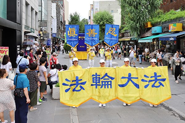 7月20日，韓國的反迫害20周年紀念活動吸引了大量行人駐足觀看。