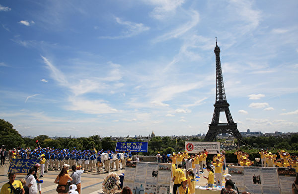 7月21日上午，欧洲天国乐团在巴黎人权广场上演奏，吸引了过往的市民和游客前来探寻法轮功真相。（章乐/大纪元）