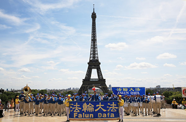 7月21日上午，歐洲天國樂團在巴黎人權廣場上演奏，吸引了過往的市民和遊客前來探尋法輪功真相。（章樂/大紀元）