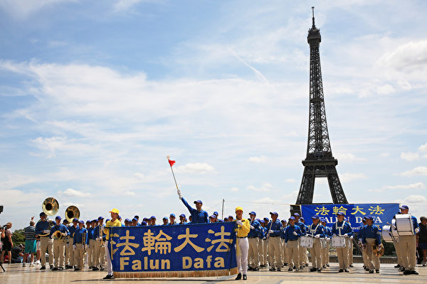 7月21日上午，歐洲天國樂團在巴黎人權廣場上演奏，吸引了過往的市民和遊客前來探尋法輪功真相。（章樂/大紀元）