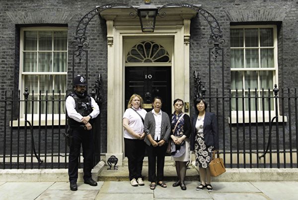 7月20日下午，英國法輪大法協會代表和幾名曾親身遭受中共迫害的先旅居英國的法輪功學員在唐寧街十號首相府門前合照。（冠奇／大紀元）