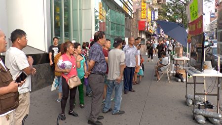 每天川流不息的華人，駐足在法拉盛緬街圖書館前，收看港人反「送中」的遊行錄像。