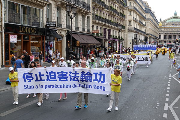 7月20日下午，來自歐洲十幾個國家的部分法輪功學員在法國巴黎舉行「紀念法輪功學員反迫害20週年」大遊行，圖為遊行隊伍途經巴黎歌劇院。（葉蕭斌/大紀元）