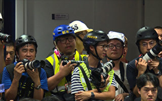 This still image taken from an AFPTV video shows Hong Kong journalists dressed in high visibility jackets and helmets during a police press conference to protest what they said was excessive force used against them during the June 12 clashes between police and protesters against a controversial extradition law proposal, in Hong Kong on June 13, 2019. - Hong Kong protest leaders announced plans for another mass rally on June 16, escalating their campaign against a China extradition bill a day after police cleared them from the streets using volleys of tear gas and rubber bullets. (Photo by AFPTV team / AFPTV / AFP) (Photo credit should read AFPTV TEAM/AFP/Getty Images)
