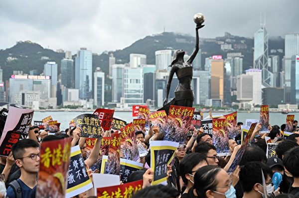 TOPSHOT - Protesters gather to take part in a march to the West Kowloon railway station, where high-speed trains depart for the Chinese mainland, during a demonstration against a proposed extradition bill in Hong Kong on July 7, 2019. - Hong Kong has been rocked by a month of huge peaceful protests as well as a series of separate violent youth-led confrontations sparked by a proposed law that would have allowed extraditions to mainland China. (Photo by Hector RETAMAL / AFP) (Photo credit should read