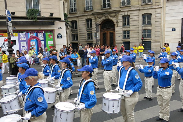 7月20日下午，來自歐洲十幾個國家的部份法輪功學員在法國巴黎舉行「紀念法輪功學員反迫害20周年」大遊行。沿途許多民眾，包括大陸遊客圍觀拍照。（葉蕭斌／大紀元）
