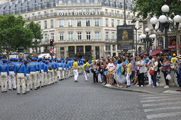 7月20日下午，來自歐洲十幾個國家的部份法輪功學員在法國巴黎舉行「紀念法輪功學員反迫害20周年」大遊行。沿途許多民眾，包括大陸遊客圍觀拍照。（葉蕭斌／大紀元）