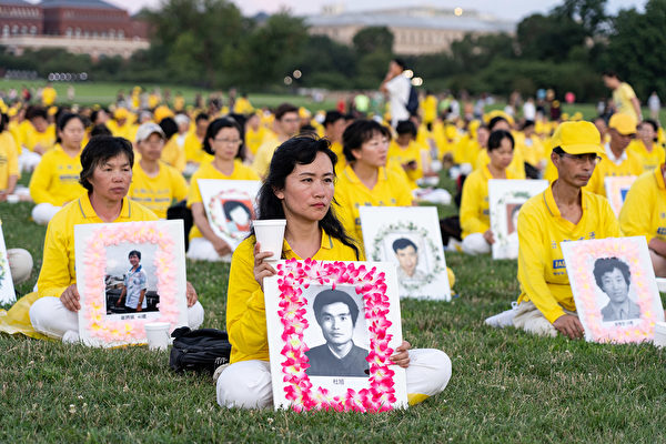 2019年7月18日，華盛頓DC，法輪功學員手持在中國大陸被迫害致死學員的遺照表達哀思。（戴兵／大紀元）