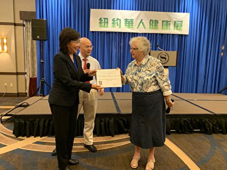 州参议员史塔文斯基（Toby Ann Stavisky）向新唐人健康展颁发褒奖。