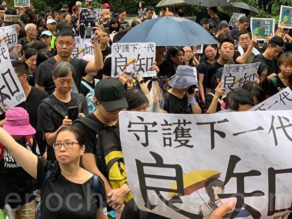 2019年8月17日，香港教育界舉行「守護下一代 為良知發聲」的集會遊行，港民舉著標語表達訴求。（駱亞／大紀元）