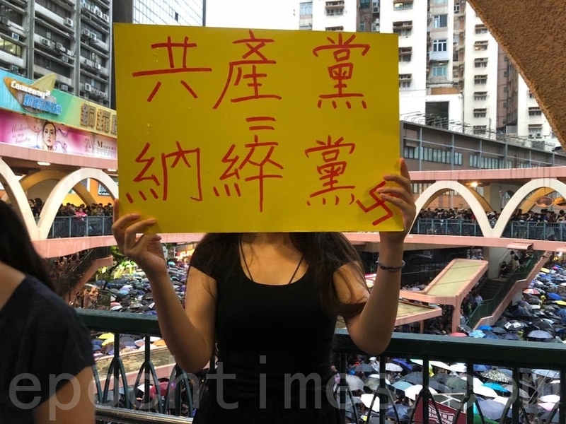 8月18日民陣在維園舉行流水式集會遊行，一名女子持抗議標語紙牌表達意見。（葉依帆／大紀元）