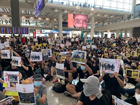 2019年8月9日，香港機場萬人接機，參加者持各式海報和標語在大堂靜坐。（駱亞／大紀元）