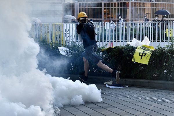 警方在金钟夏悫道一再施放催泪弹。示威者在奔走避开催泪烟。（ANTHONY WALLACE/AFP/Getty Images)