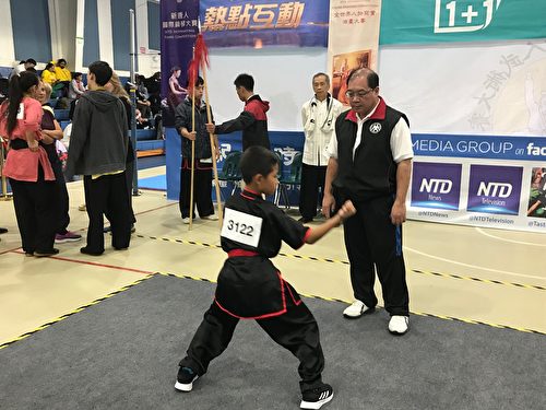 姜新銀先生（右一）正指導9歲小選手楊曉樂，後者以大內八極拳獲少年組銅獎。（趙芬妮／大紀元）