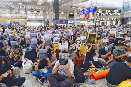 2019年8月9日，香港機場萬人接機，參加者持各式海報和標語在大堂靜坐。（宋碧龍／大紀元）