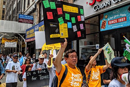 聲援臺灣加入聯合國大遊行，民眾手舉連儂牆展板，聲援香港反送中抗議運動。