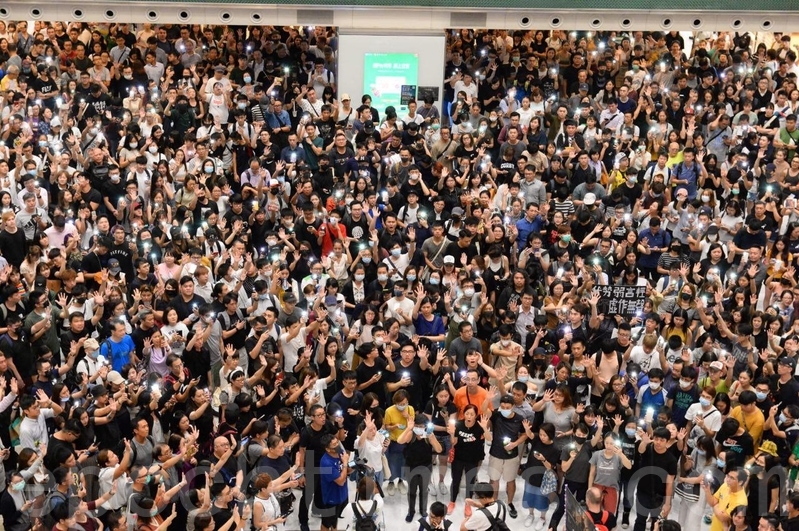2019年9月11日，香港市民在沙田新城市廣場齊唱「願榮光歸香港」，市民抬起手臂，展開手掌，代表五大訴求缺一不可。（黃曉翔／大紀元）