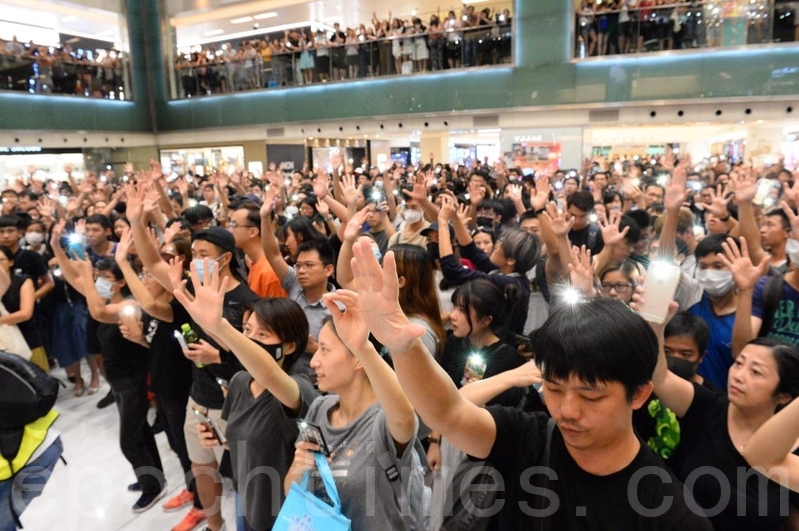 2019年9月11日，香港市民在沙田新城市廣場齊唱「願榮光歸香港」，市民抬起手臂，展開手掌，代表五大訴求缺一不可。（黃曉翔／大紀元）