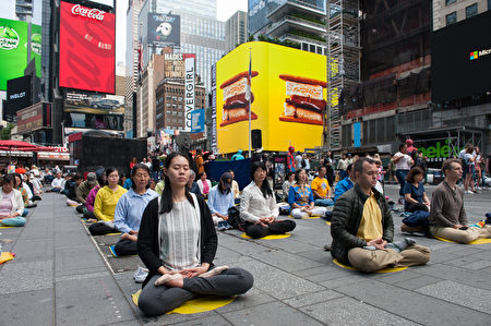 中西法轮功学员在纽约著名景点时代广场炼功弘法，图为在炼第五套功法——神通加持法。