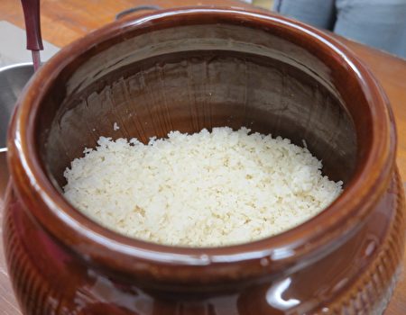 煮熟的米加入高粱麹，即完成第一天的酿制工作。