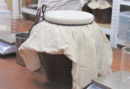 加入高粱麹的熟米用棉布盖住瓮口，并用麻绳绑好，第二天开盖时就能闻到酒香。