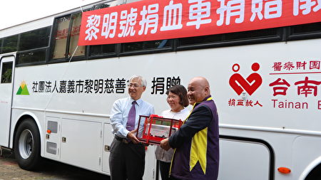  由台湾血液基金会执行长魏昇堂(左)回赠捐血车模型，由嘉义市黎明慈善会理事长施达华(右)代表接受