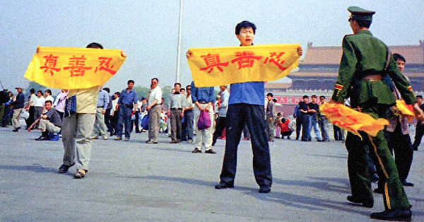 法輪功學員在北京天安門廣場上請願，打出寫著中文「真善忍」的橫幅。他們面對被抓被打的危險（明慧網）