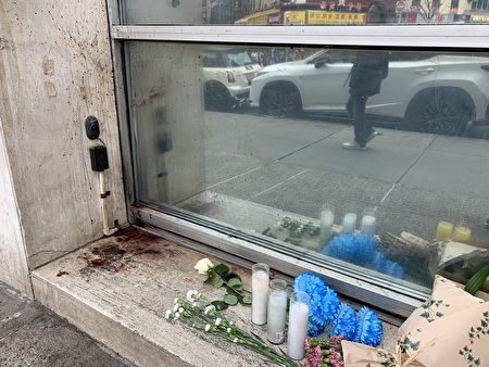 包厘街2號83歲華翁命案現場，民眾自發擺上鮮花和蠟燭悼念。左側墻上、臺階上的血跡仍清晰可見。