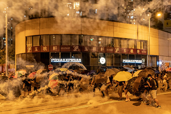 2019年10月3日，防暴警察發射催淚彈，民眾用雨傘抵禦。（Anthony Kwan／Getty Images）