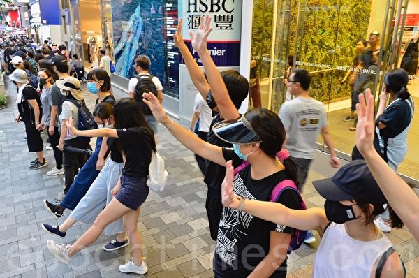 2019年10月5日，香港民眾發起港島遊行，圖為佐敦彌敦道人鏈，民眾伸出五個手指表達「五大訴求 缺一不可」。（余天祐／大紀元）