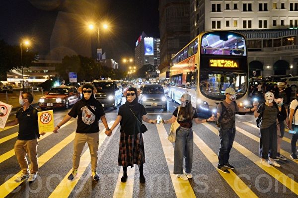 2019年10月18日，尖沙咀，香港市民戴上口罩和面具築人鏈。（宋碧龍／大紀元）