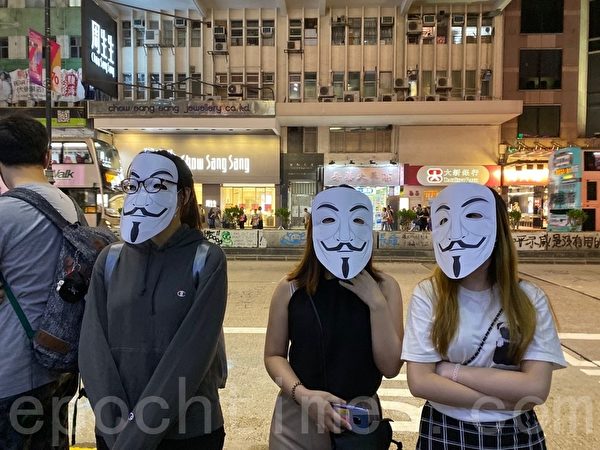 2019年10月18日，香港市民在旺角蒙面人鏈。圖為抗爭者戴各種公仔面具。（駱亞／大紀元）