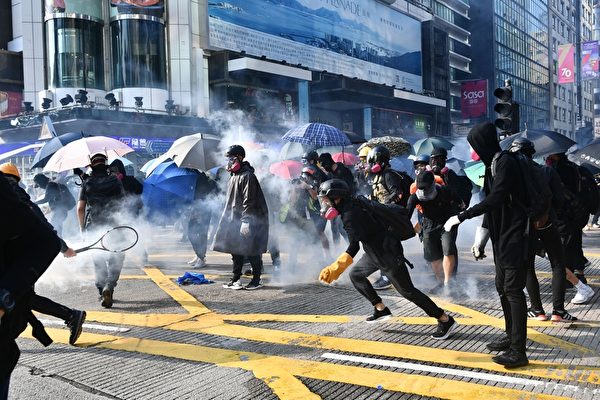 2019年10月20日，九龍區大遊行防暴警察向抗爭者發射催淚彈。（ANTHONY WALLACE/AFP via Getty Images）