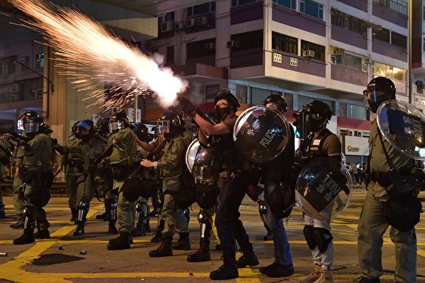 2019年10月20日，九龍區大遊行防暴警察向抗爭者發射催淚彈。（ED JONES/AFP via Getty Images）