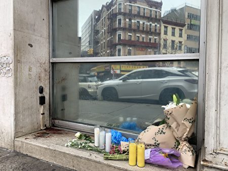 包厘街2號83歲華翁命案現場，民眾自發擺上鮮花和蠟燭悼念。左側墻上、臺階上的血跡仍清晰可見。