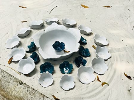 “奉茶惜福”白沙上的花型茶杯。 