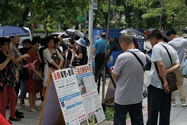 台北國父紀念館前，大陸遊客認真閱讀法輪功真相展板。（明慧網）