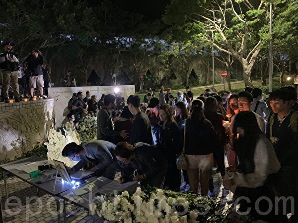 2019年11月8日，香港科大學生設立悼念周同學的祭壇。圖為科大學生拿著燭光悼念。（韓納／大紀元）