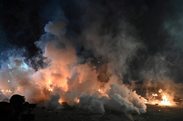 2019年11月12日，警方施放催淚彈煙霧瀰漫，地上有火苗。（Philip FONG/AFP）
