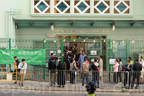 2019年11月24日，香港2019區議會選舉，羅便臣道投票站高主教書院票站一早已有選民進去投票。（余鋼／大紀元）
