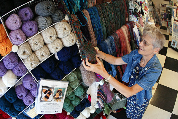 DES PLAINES, IL - JULY 26: Sixty-eight-year-old Barb Blume arranges yarn at the Mosaic Yarn Studio July 26, 2002 in Des Plaines, Ilinois. Blume is a retired nurse who turned her hobby of knitting into a second career at the yarn studio where she is the assistant manager and knitting class instructor. (Photo by Tim Boyle/Getty Images)