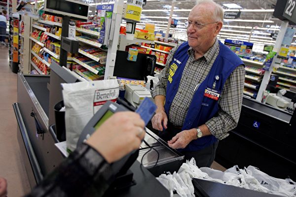 BOWLING GREEN, OH - MAY 17: Clayton Fackler, 72, works at the check out at the new 2,000 square foot Wal-Mart Supercenter store May 17, 2006 in Bowling Green, Ohio. The new store, one of three new supercenters opening today in Ohio, employs 340 people with 60 percent of those working full-time. (Photo by J.D. Pooley/Getty Images)