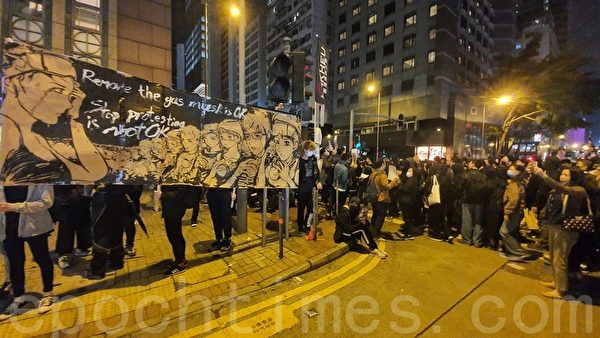 12月8日游行中，有市民举着制作的漫画表达诉求。（余钢／大纪元）
