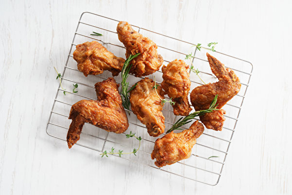 將炸雞放在紙巾上，會讓炸皮變得潮濕，失去酥脆的口感。建議使用炸籃或金屬架。（Fotolia） Fried chicken wings with fresh herbs