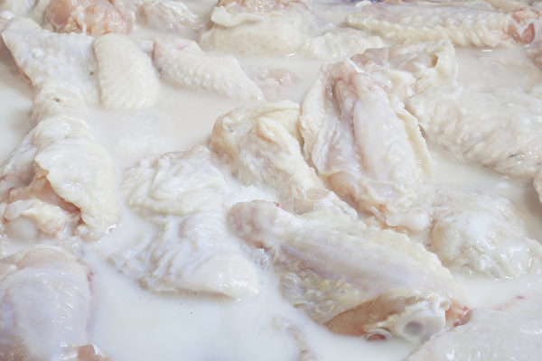 用白脱牛奶腌鸡肉，能让鸡肉吃起来更软嫩。（Fotolia） Raw Chicken Wings marinating in buttermilk